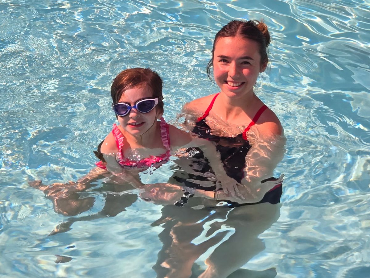 A coach and child at the pool wall